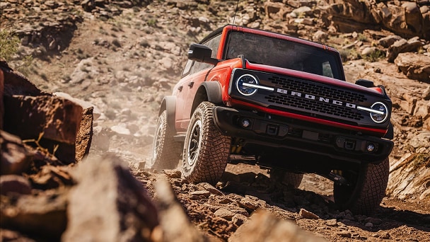 Red Ford Bronco Sport® driving through a muddy terrain